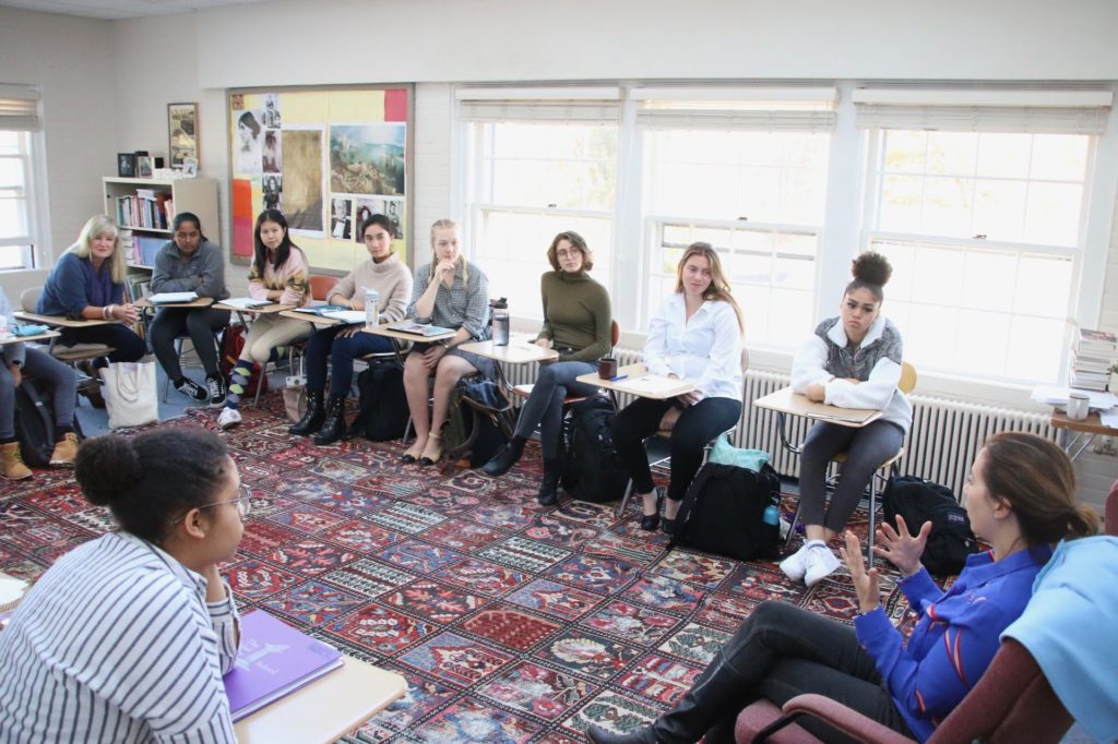 Group of students in a circle listening to visiting writer