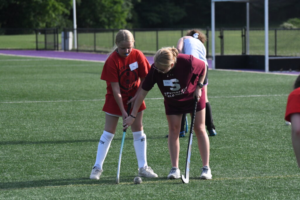 Photograph-alumnae-Grace-Majka-instructs-field-hockey-camper-in-hand-positioning